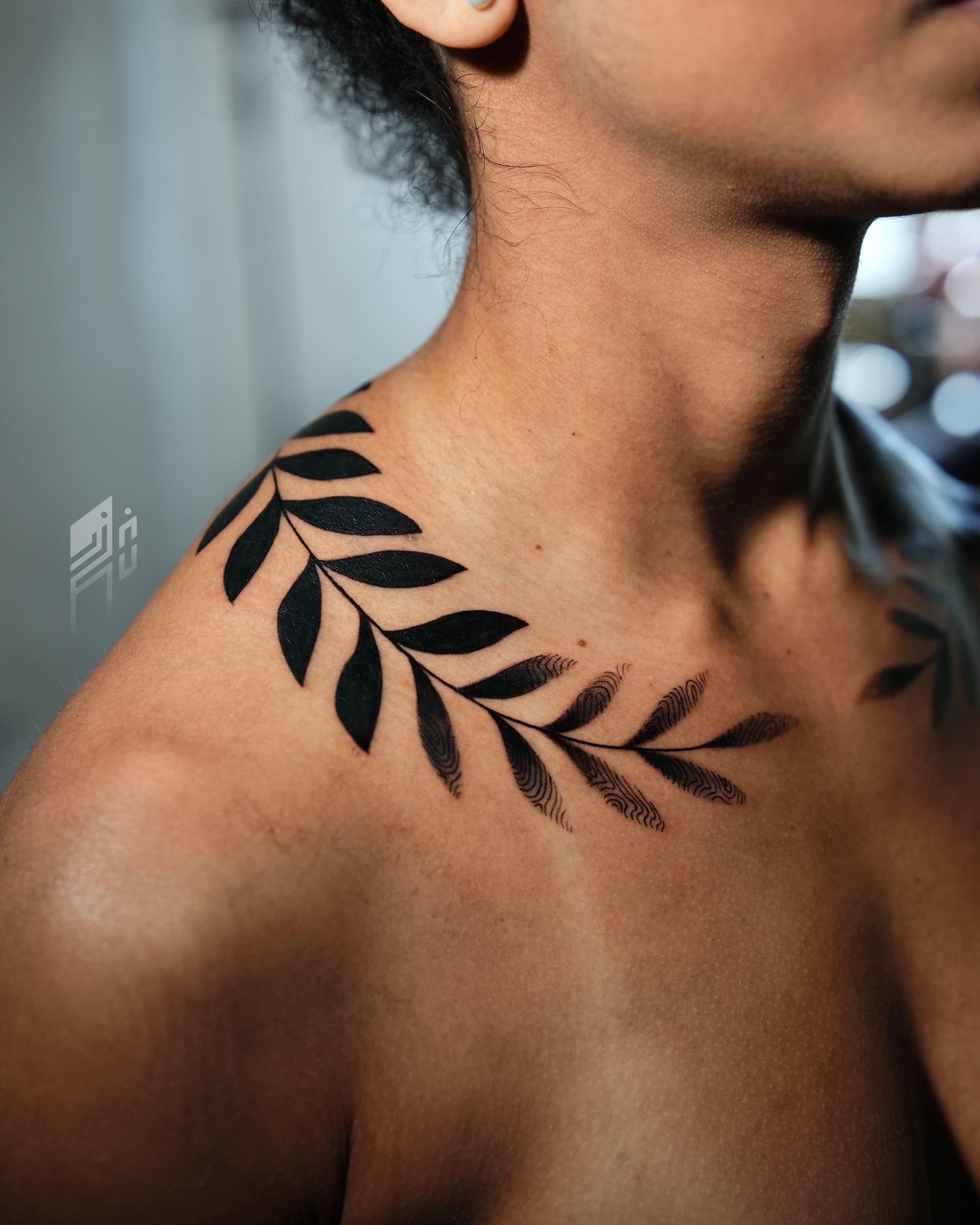 Tatuaje blackwork de una rama de hojas envolviendo la clavícula y el hombro, hecho por Rivas Indeed en San Juan, Puerto Rico
