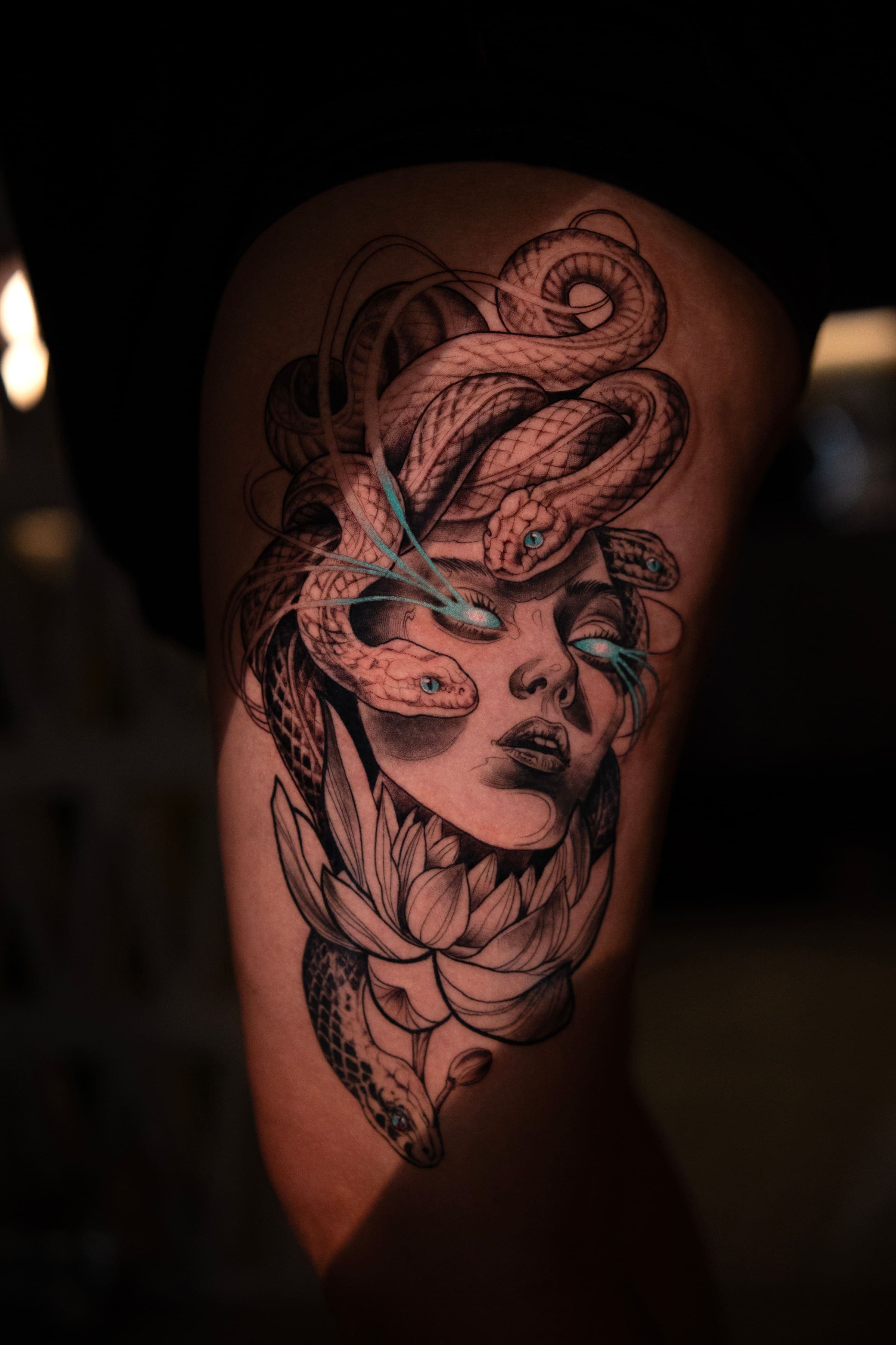Black and grey tattoo of Medusa with snake hair and a lotus flower, on the arm, by Rivas Indeed, tattoo artist in San Juan, Puerto Rico